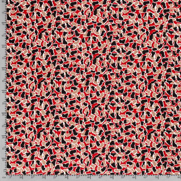 Tejido de viscosa con estampado de manchas sobre fondo rojo