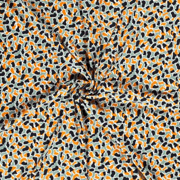 Tejido de viscosa con estampado de manchas sobre fondo verde