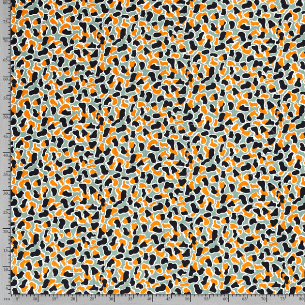 Tejido de viscosa con estampado de manchas sobre fondo verde