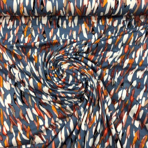 Tejido de viscosa con estampado de pétalos de colores fondo azul