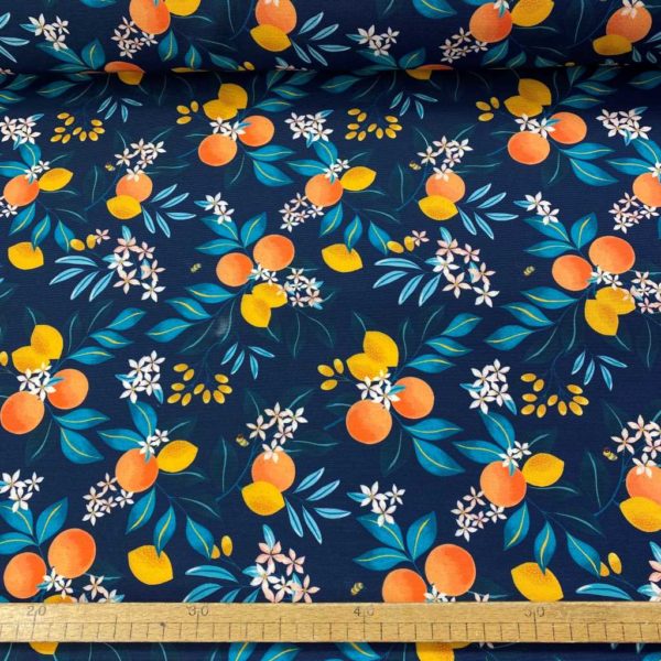 Mantelería antimanchas de poliéster estampado de ramas floreadas con naranjas y liomnes y abejas polinizadoras