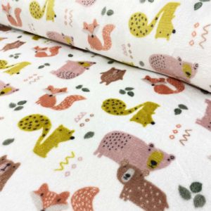 Tela de coralina estampada con animalitos de colores fondo color blanco roto, muy suave y caliente.