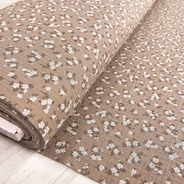 Tela de muselina o tela de doble gasa, algodón 100x100. Tejido con estampado de florecitas blancas fondo marrón beige