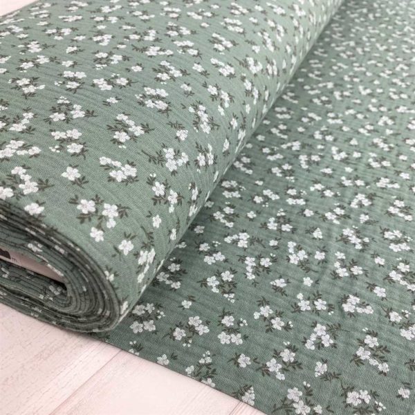 Tela de muselina o tela de doble gasa, algodón 100x100. Tejido con estampado de florecitas blancas fondo verde mint