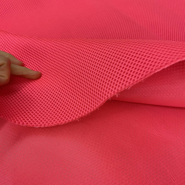 La malla 3D es un tejido transpirables, que no retiene el agua y es de secado rápido. Color rosa flúor.