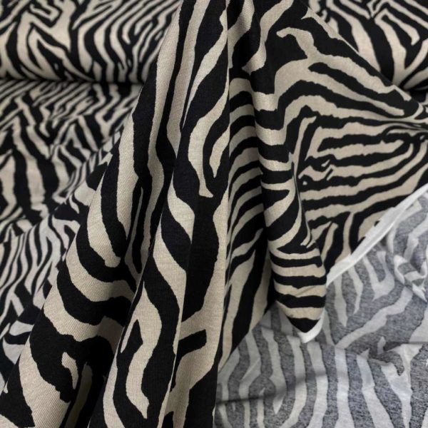 Tela de punto de viscosa elástica estampada animal print zebra en color gris y negro.