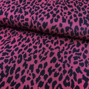 Tela de vestir de viscosa 100% tipo twill o sarga, con estampado animal print de leopardo con manchas en negro y fondo fucsia.