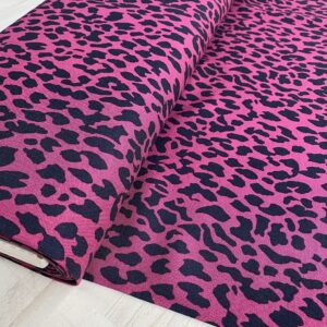 Tela de vestir de viscosa 100% tipo twill o sarga, con estampado animal print de leopardo con manchas en negro y fondo fucsia.