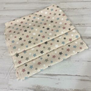Retal de loneta estampada con algodón y poliéster con estrellitas de colores fondo crudo.
