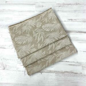 Retal de loneta estampada con algodón y poliéster con hojas de palmera blancas estampadas con plantilla.