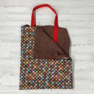 Pack Tote Bag con tela de gobelino estampado con rombos pequeños de colores, interior jaspeado rojo y cinta de espiga de 3 mm en color rojo.