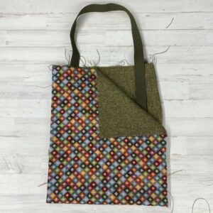 Pack Tote Bag con tela de gobelino estampado con rombos pequeños de colores, interior jaspeado verde y cinta de espiga de 3 mm en color verde.