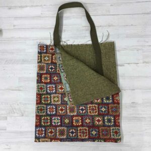 Pack Tote Bag con tela de gobelino estampado con flores tipo patchwork de colores, interior jaspeado verde y cinta de espiga de 3 mm en color verde.