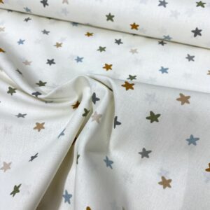 Tela de algodón estampada con estrellitas de colores fondo beige. Tela de algodón tipo popelín para todo tipo de creatividades de Patchwork, manualidades o confecciones creativas.