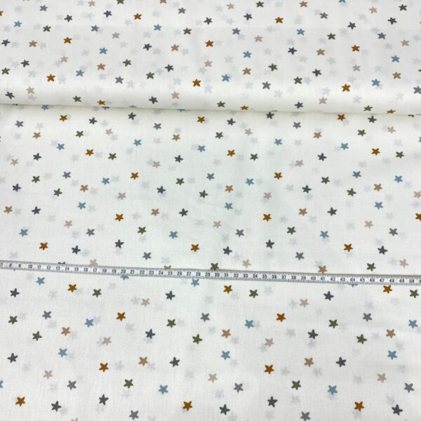 Tela de algodón estampada con estrellitas de colores fondo beige. Tela de algodón tipo popelín para todo tipo de creatividades de Patchwork, manualidades o confecciones creativas.