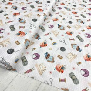 Tela de algodón estampada con temas de costura como máquinas de coser, lanas, hilos, telas y tijeras. Tela de algodón tipo popelín para todo tipo de creatividades de Patchwork, manualidades o confecciones creativas.