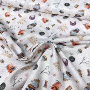 Tela de algodón estampada con temas de costura como máquinas de coser, lanas, hilos, telas y tijeras. Tela de algodón tipo popelín para todo tipo de creatividades de Patchwork, manualidades o confecciones creativas.