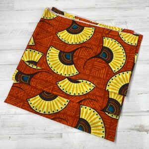 Loneta con estampado tipo africano wax con formas de abanicos amarillas y fondo teja. Con colores muy vivos. Tejido muy versátil y resistente. Ideal para todo tipo de manualidades.