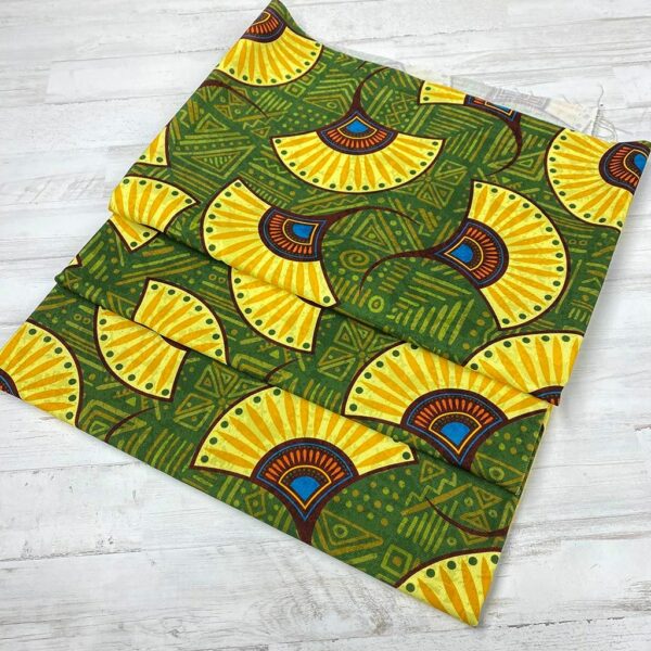 Loneta con estampado tipo africano wax con formas de abanicos amarillas y fondo verde. Con colores muy vivos. Tejido muy versátil y resistente. Ideal para todo tipo de manualidades.