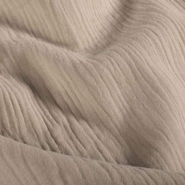 Tela de muselina o doble gasa de algodón beige. Tejido de algodón muy suave y ligero. Textura rugosa y transiprable. Ideal para confecciones del hogar o infantiles.