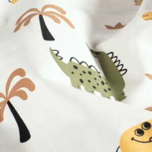 Tela de punto de camiseta de algodón orgánico. Tipo Jersey estampado con dinosaurios en color amarillo, verde y beige fondo blanco roto.