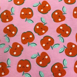 Tela de punto de camiseta de algodón orgánico. Tipo Jersey estampado con manzanas alegres fondo rosa fucsia.