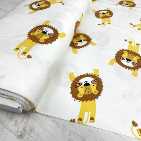 Tela de punto de camiseta de algodón orgánico. Tipo Jersey estampado con leones amarillos y marrones fondo blanco roto