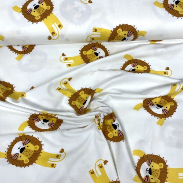 Tela de punto de camiseta de algodón orgánico. Tipo Jersey estampado con leones amarillos y marrones fondo blanco roto