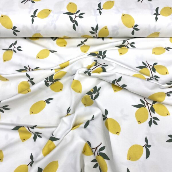 Tela de punto de camiseta de algodón orgánico. Tipo Jersey estampado con limones amarillos fondo blanco roto
