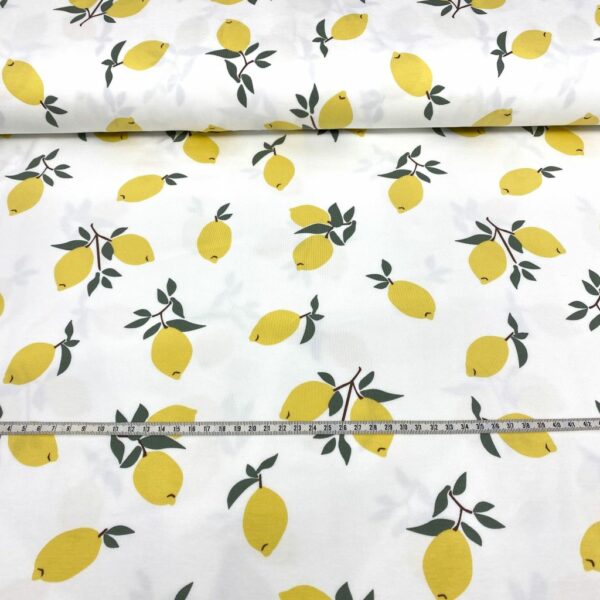 Tela de punto de camiseta de algodón orgánico. Tipo Jersey estampado con limones amarillos fondo blanco roto