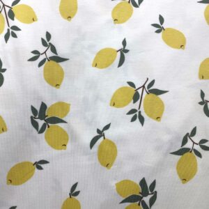 Tela de punto de camiseta de algodón orgánico. Tipo Jersey estampado con limones amarillos fondo blanco roto