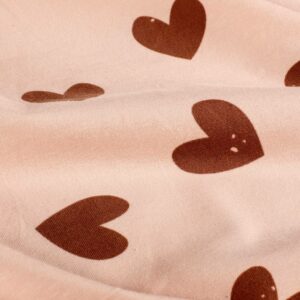 Tela de punto de camiseta de algodón orgánico. Tipo Jersey estampado con corazones rojos fondo rosa palo.