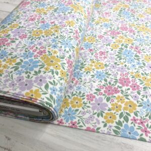 Tela de punto de camiseta de algodón orgánico. Tipo Jersey estampado con flores de colores fondo blanco roto.
