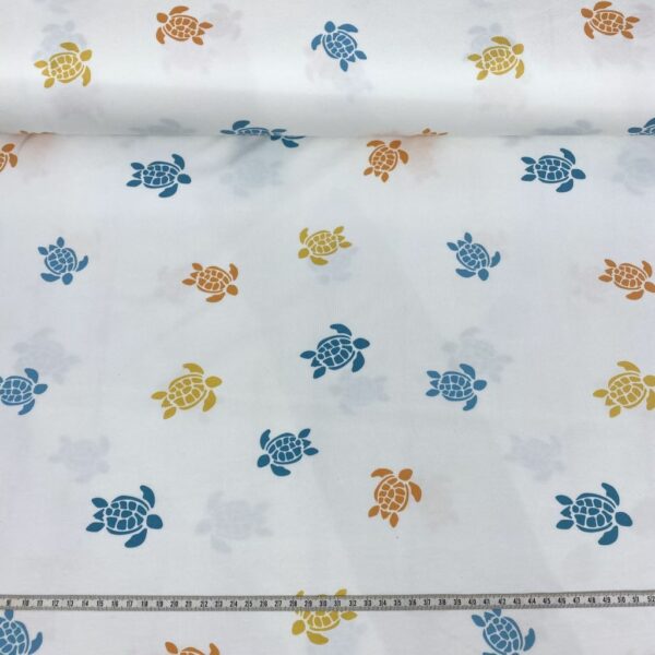 Tela de punto de camiseta de algodón orgánico. Tipo Jersey estampado con tortugas amarillas, naranjas y azules fondo blanco roto