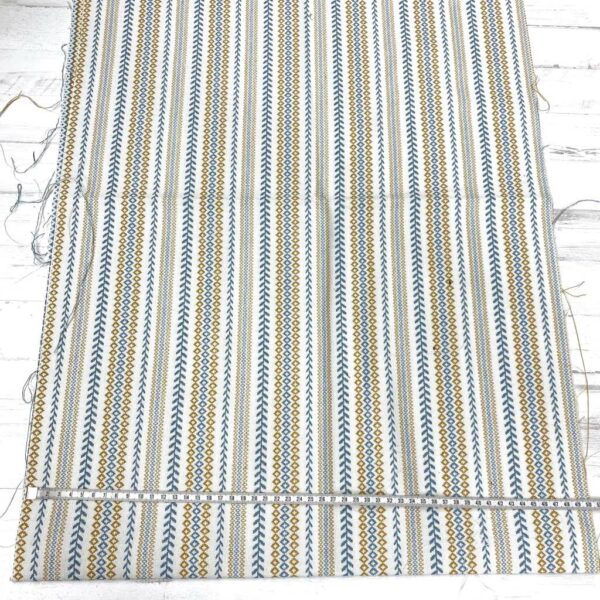 Retal de tela de tapicería gobelino estampado con cenefa en azul y ocre fondo crudo.