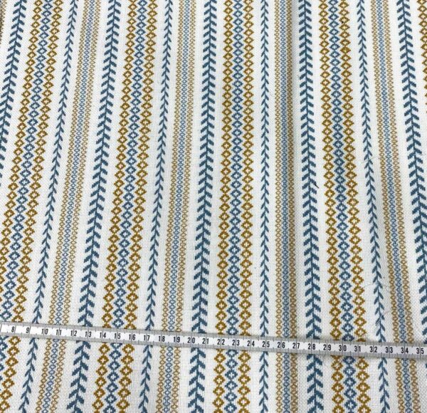 Retal de tela de tapicería gobelino estampado con cenefa en azul y ocre fondo crudo.