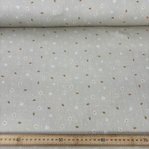 Fondo beige con pequeñas flores blancas y detalles dorados.