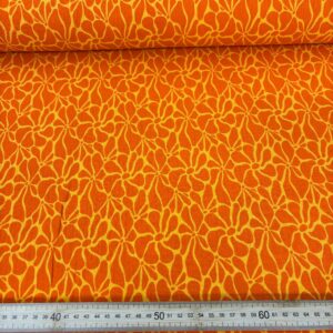 Muselina estampada con patrón floral en tonos naranja y amarillo, ideal para proyectos de verano.