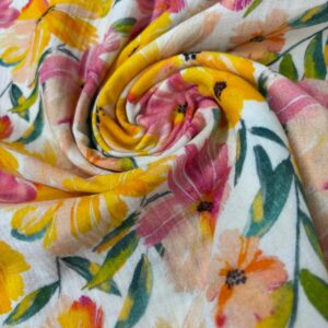 Muselina de algodón con estampado de flores en tonos amarillos y rosas, ideal para decorar espacios con un toque vibrante y natural.
