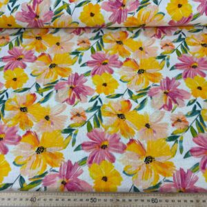 Muselina de algodón con estampado de flores en tonos amarillos y rosas, ideal para decorar espacios con un toque vibrante y natural.