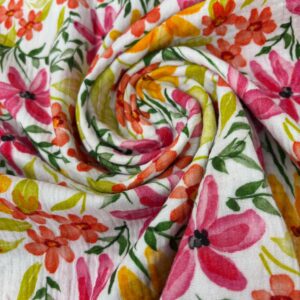Muselina de algodón con diseño floral en tonos rosa, naranja y verde.