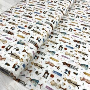 Tela de algodón con diseño de lapiceros y objetos antiguos, ideal para manualidades y costura.