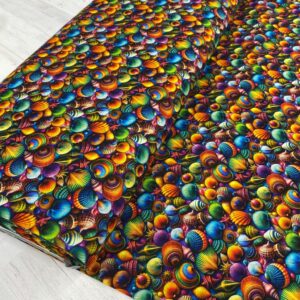 Algodón tipo popelín con estampado de de caracolas en colores vivos. Ideal para confecciones de verano.