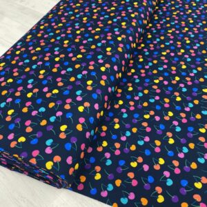 Tecido de algodón con diseño de cerezas en colores vibrantes, ideal para proyectos creativos y moda.