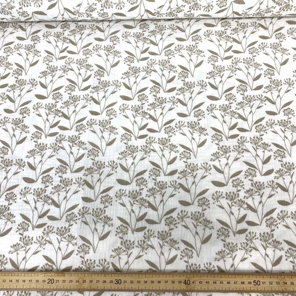 Estampado de muselina con palmeras y plantas tropicales en tonos neutros.