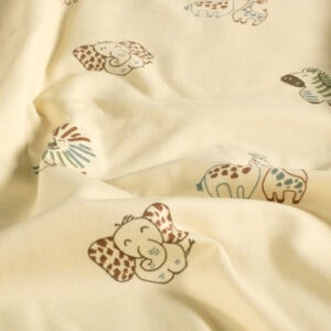 Cojín infantil con diseño de animales en colores suaves, ideal para habitaciones infantiles en Grano.