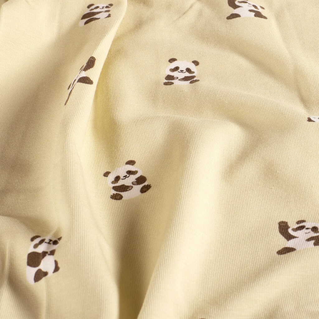 Panda de tela con estampado de pandas en fondo beige, ideal para proyectos de costura y decoración.